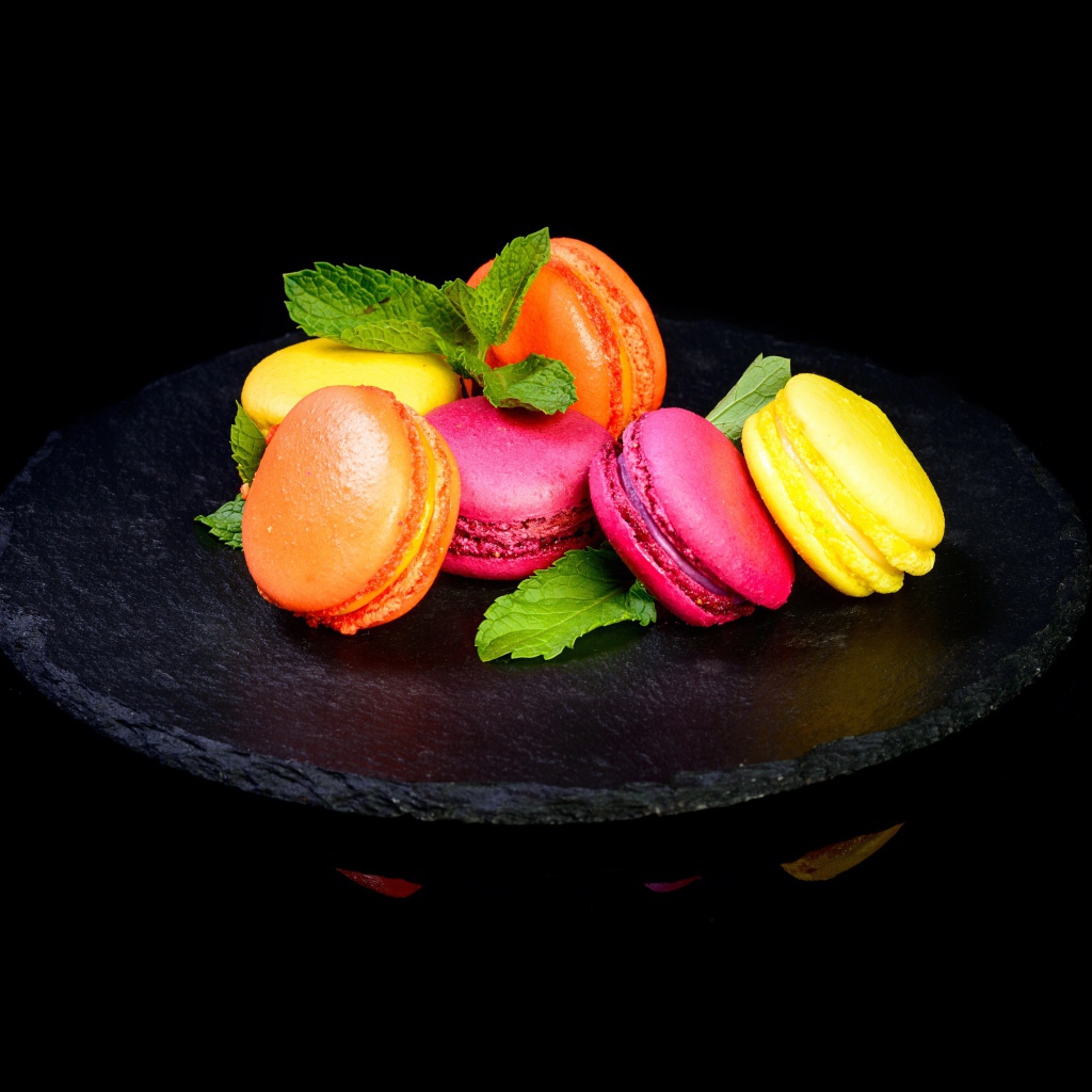 Разноцветный десерт макарон на черном фоне