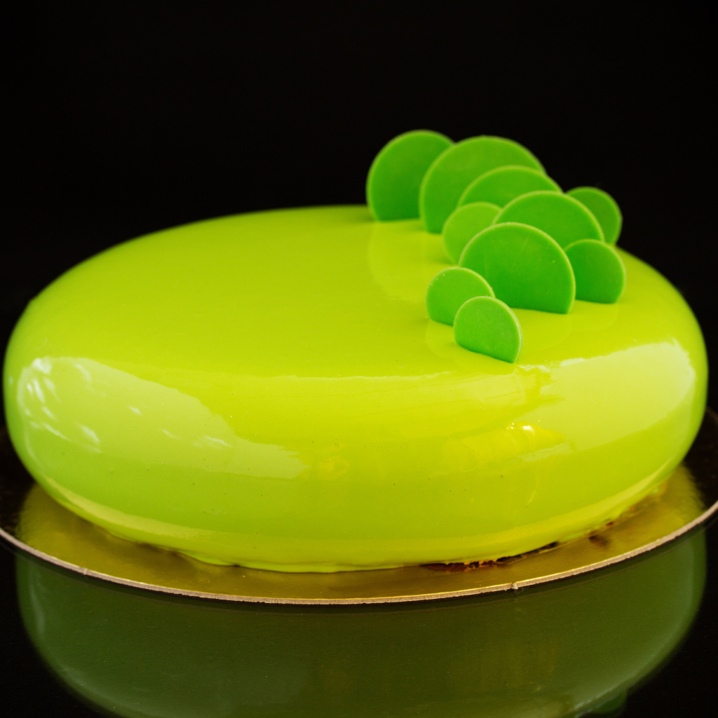 Круглый красивый глянцевый торт на черном фоне