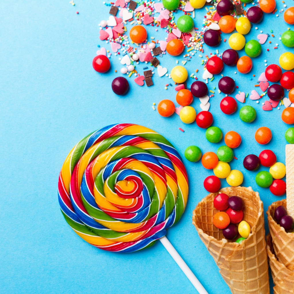 Сладкие конфеты и вафельные рожки на голубом фоне