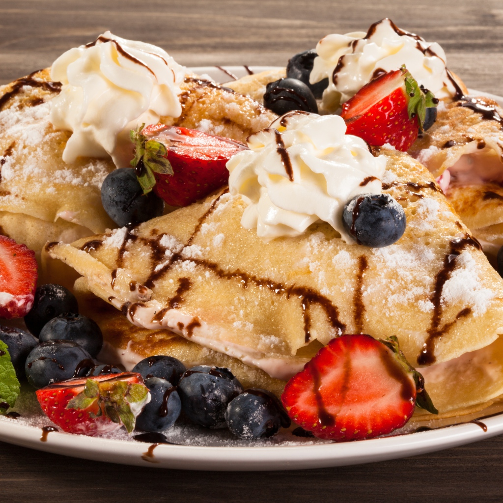 Сладкие блины с кремом, ягодами клубники и черники