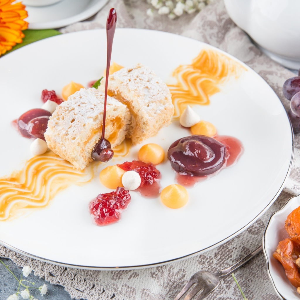 Сладкий рулет с сухофруктами и джемом на тарелке 