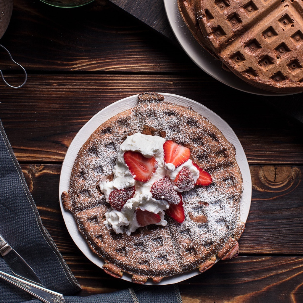 Сладкие вафли со сливками и ягодами клубники 