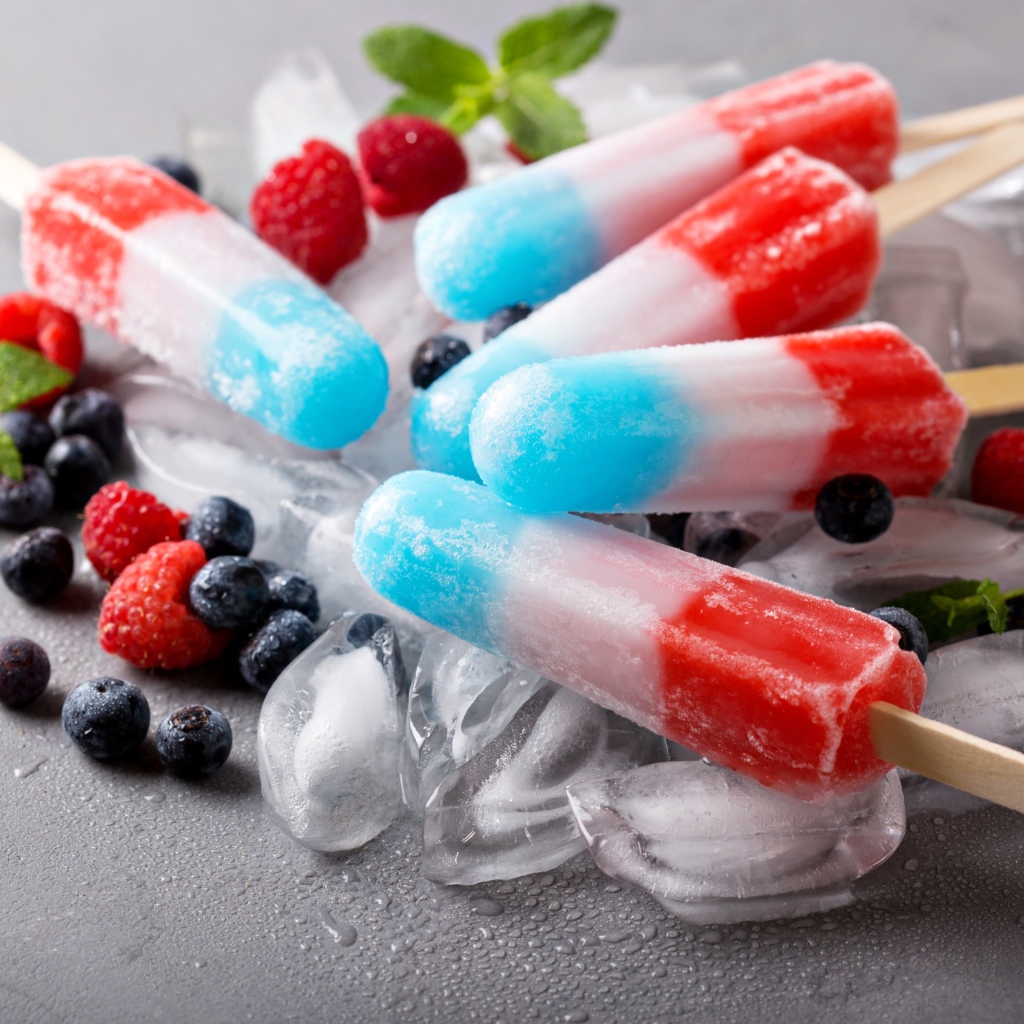Трехцветное фруктовое мороженое лежит на кусочках льда
