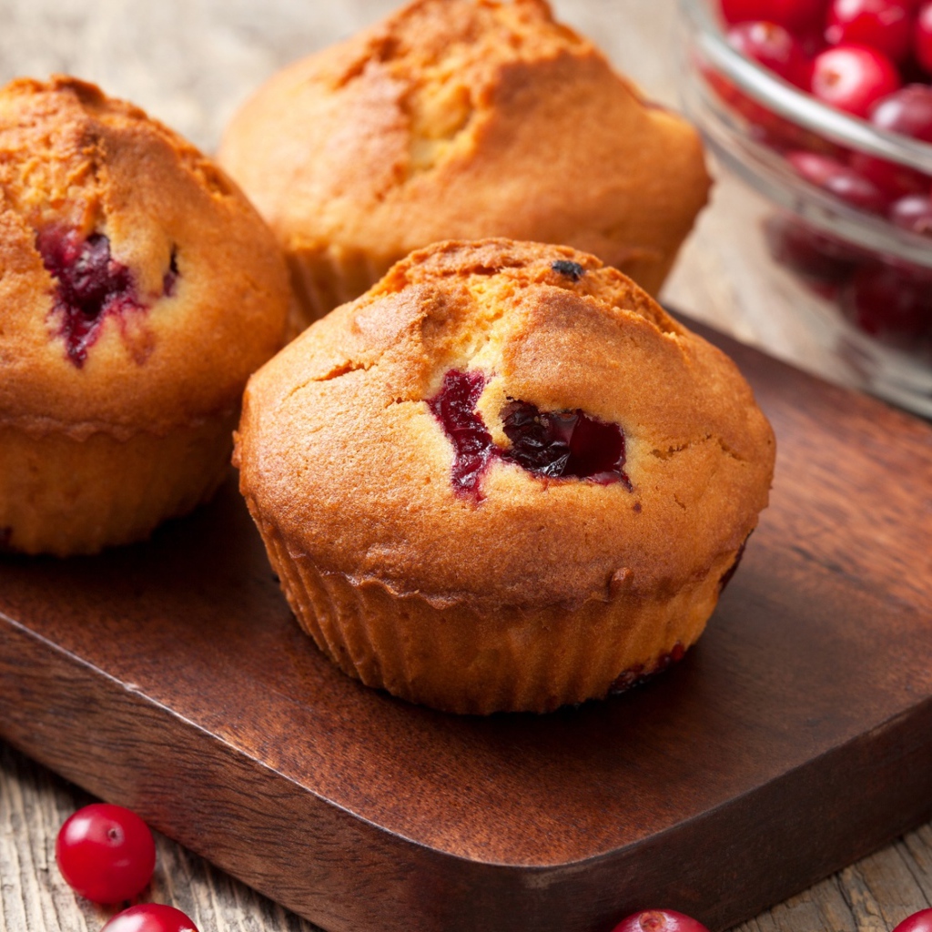 Три кекса с клюквой на разделочной доске