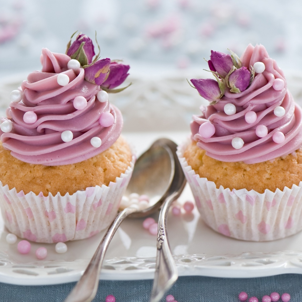 Два вкусных капкейка с кремом на тарелке