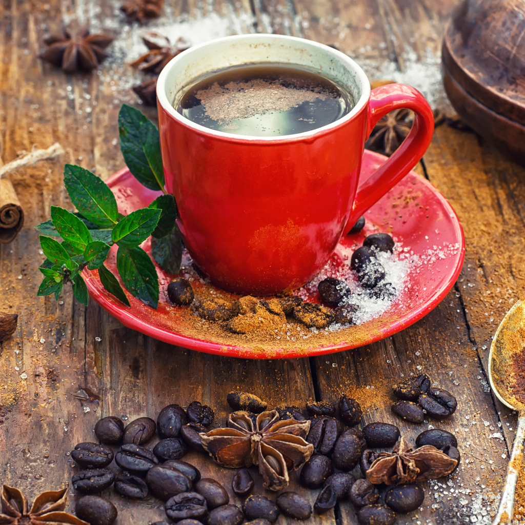 Чашка кофе на столе с зернами, корицей и зернами бадьяна 