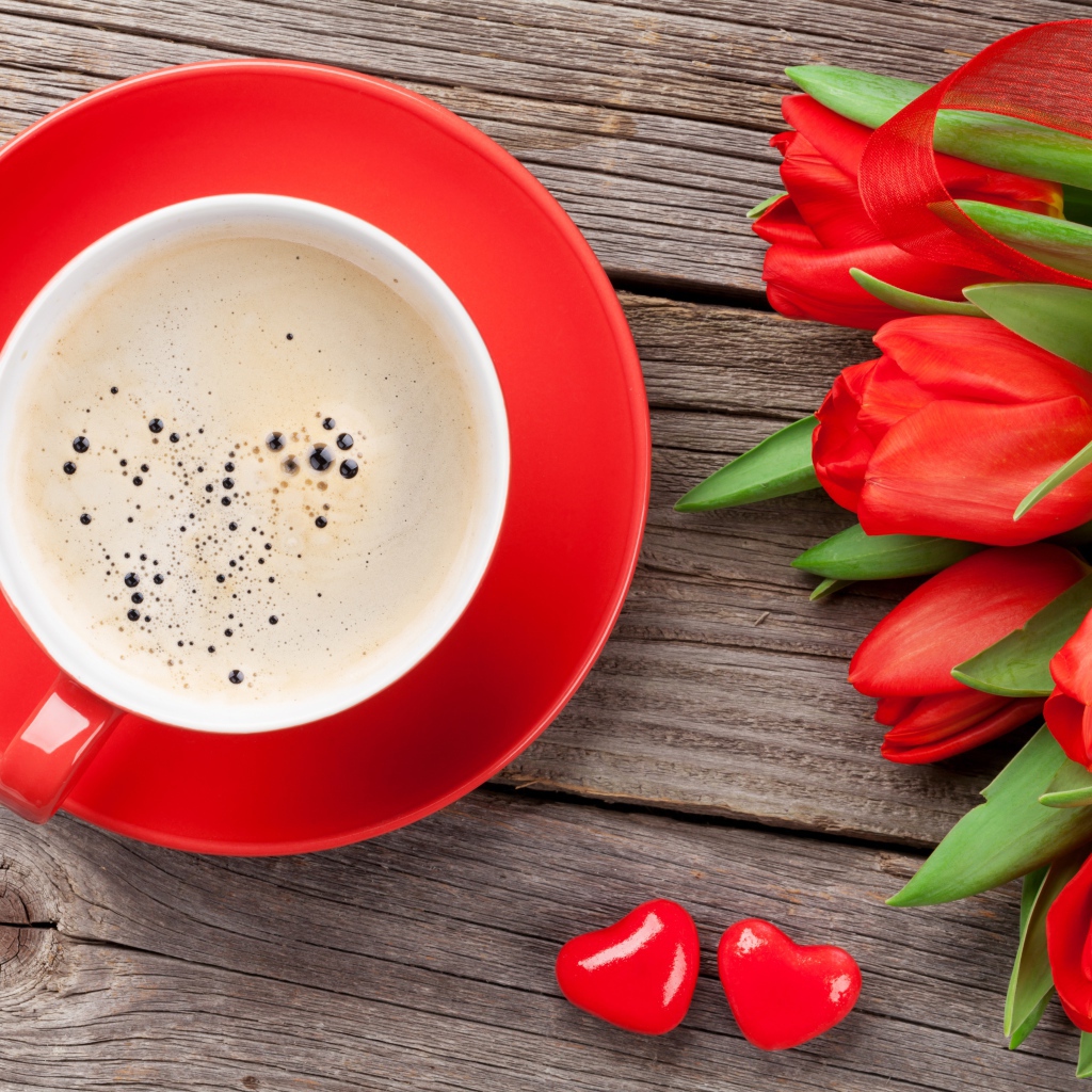 Чашка кофе с красными тюльпанами на деревянном столе 
