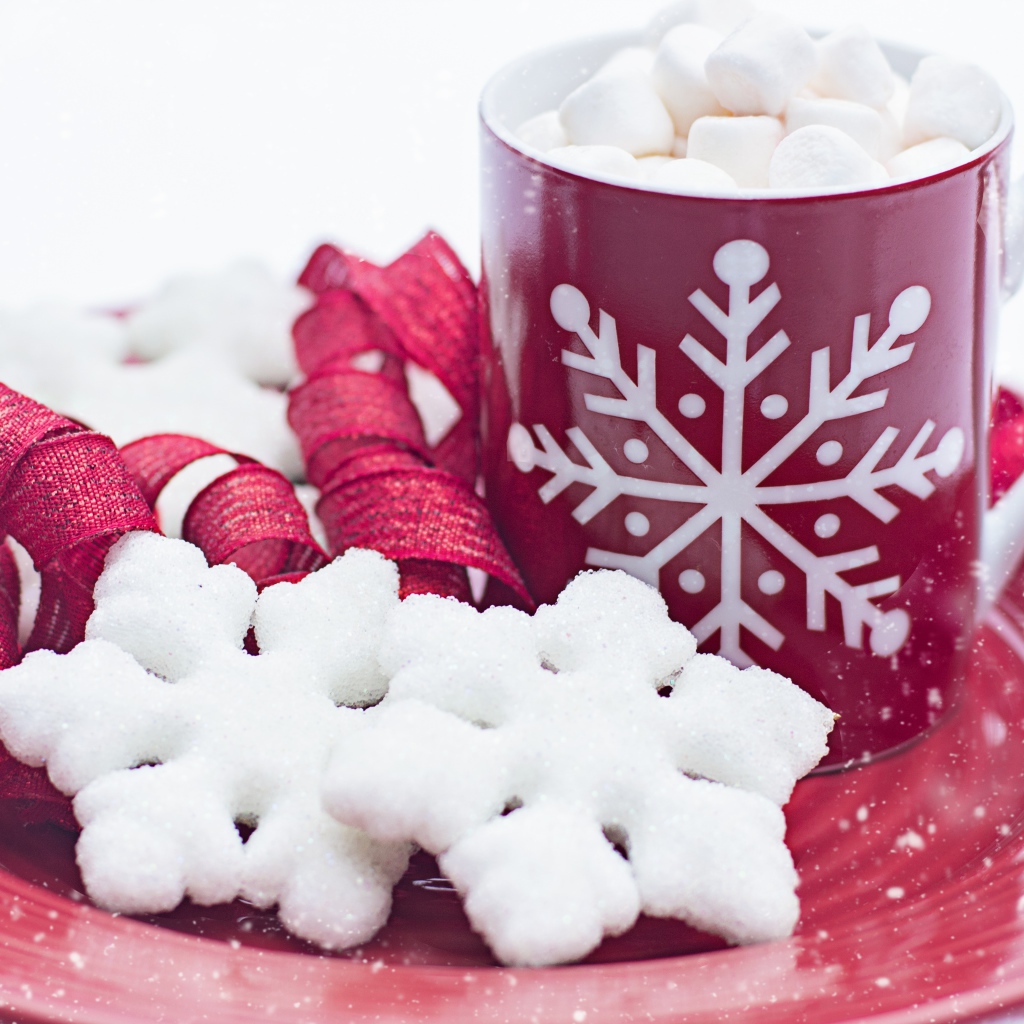 Чашка горячего шоколада с маршмеллоу на тарелке со снежинками