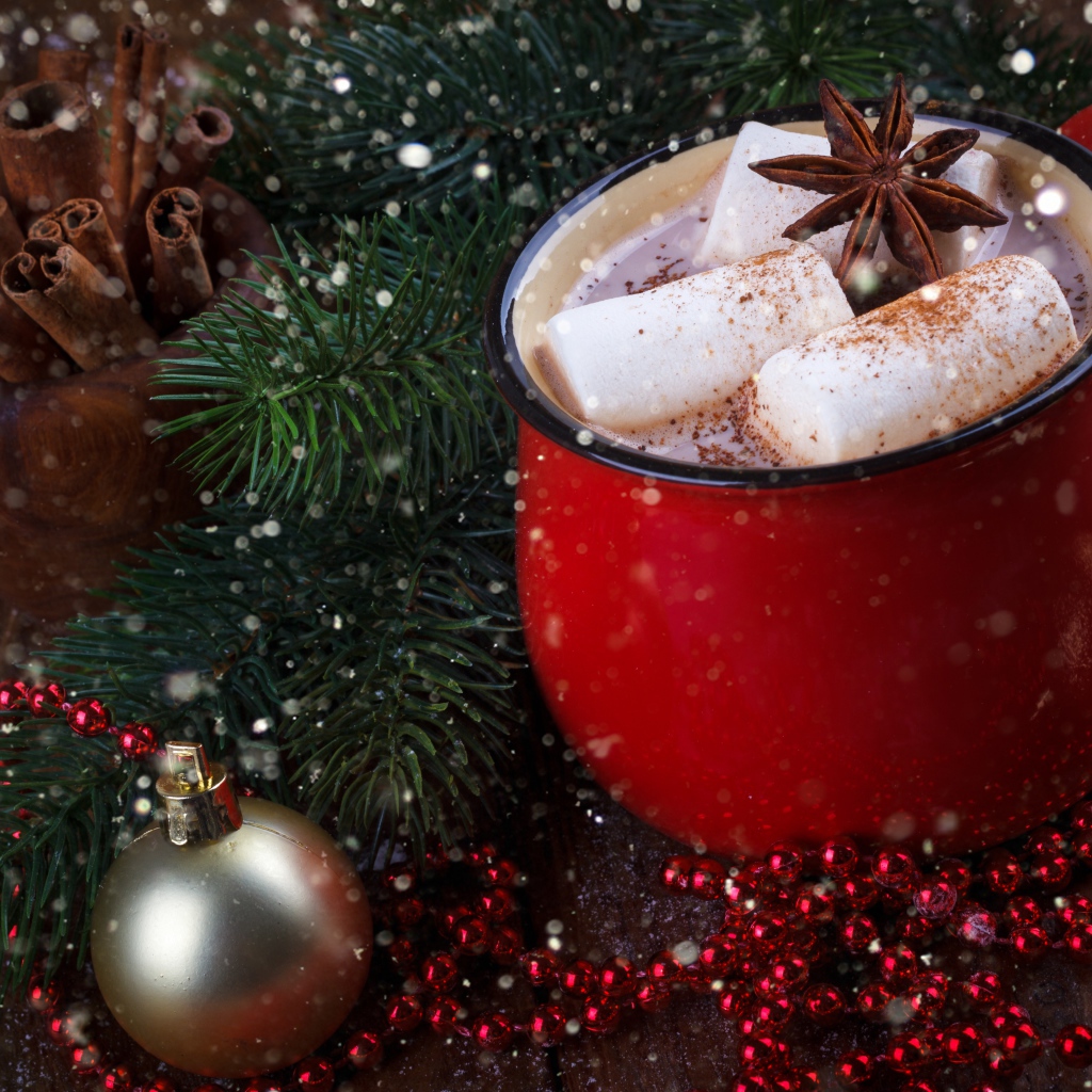 Чашка горячего какао с кусочками маршмеллоу и бадьяном на столе с еловой веткой 