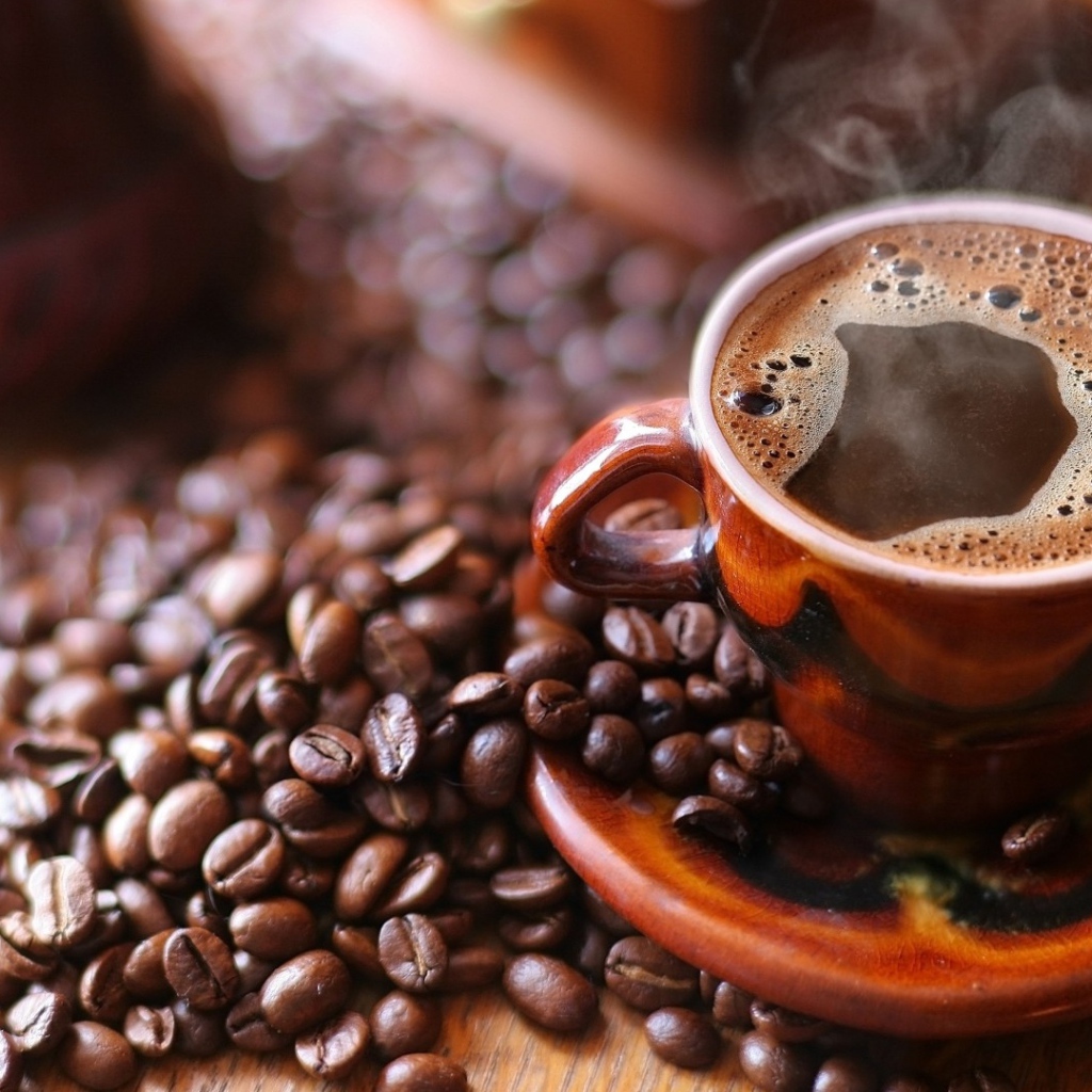 Чашка горячего кофе на столе с кофе 