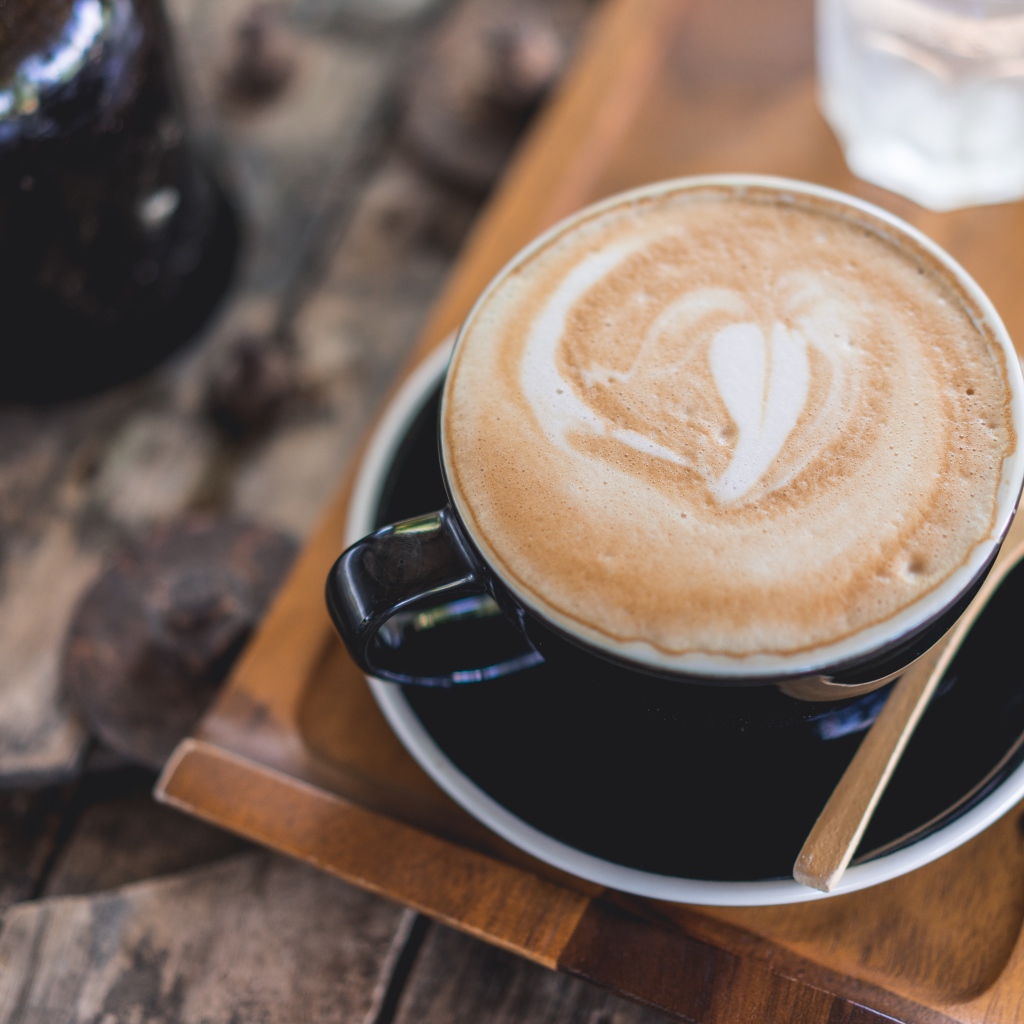 Большая чашка кофе с пеной на столе