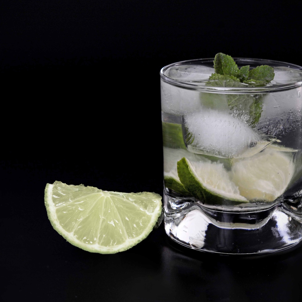 Коктейль кайпиринья на черном фоне с кусочком лайма