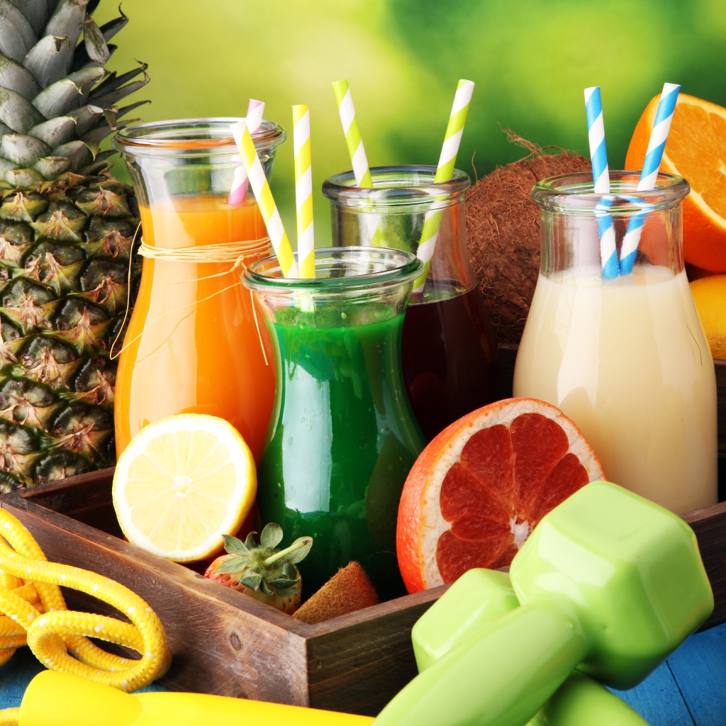 Коктейли в бутылках с трубочками на столе фруктами