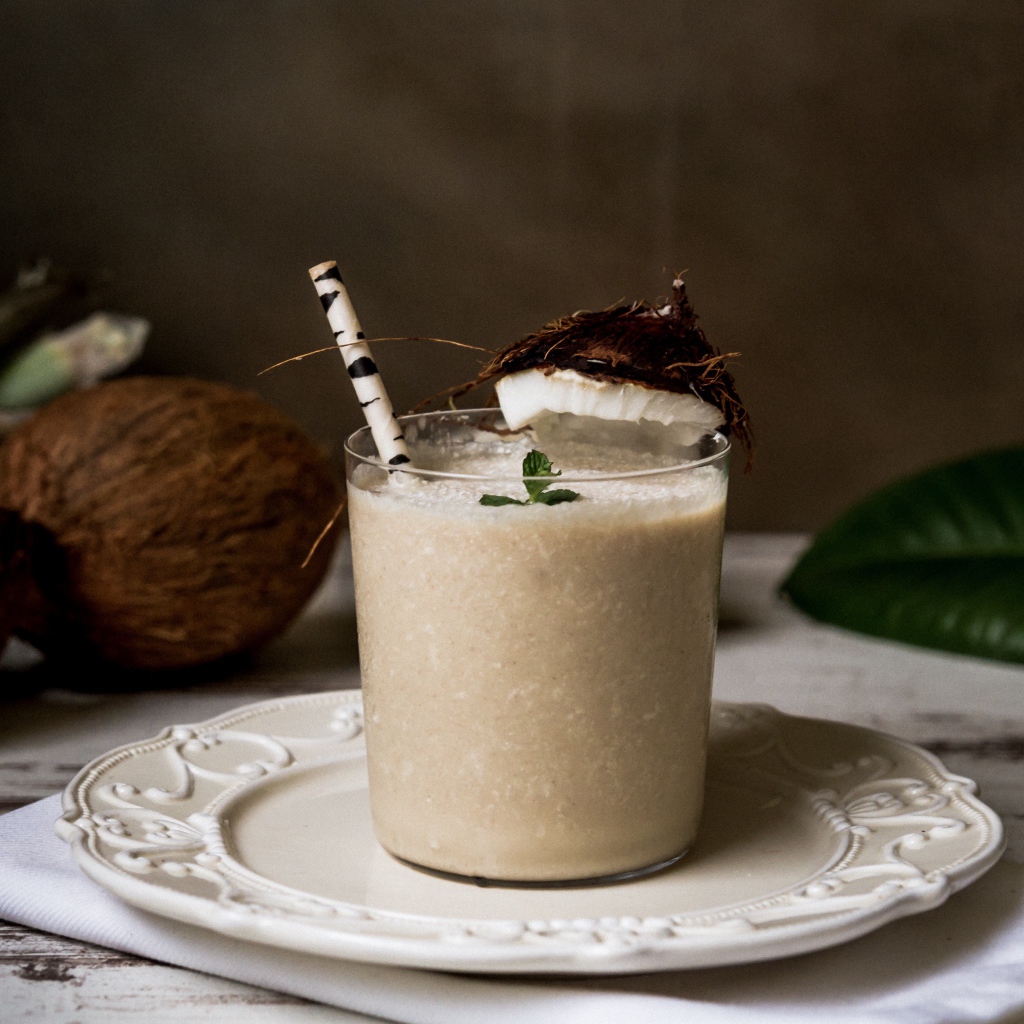 Вкусный кокосовый коктейль в стакане с трубочкой