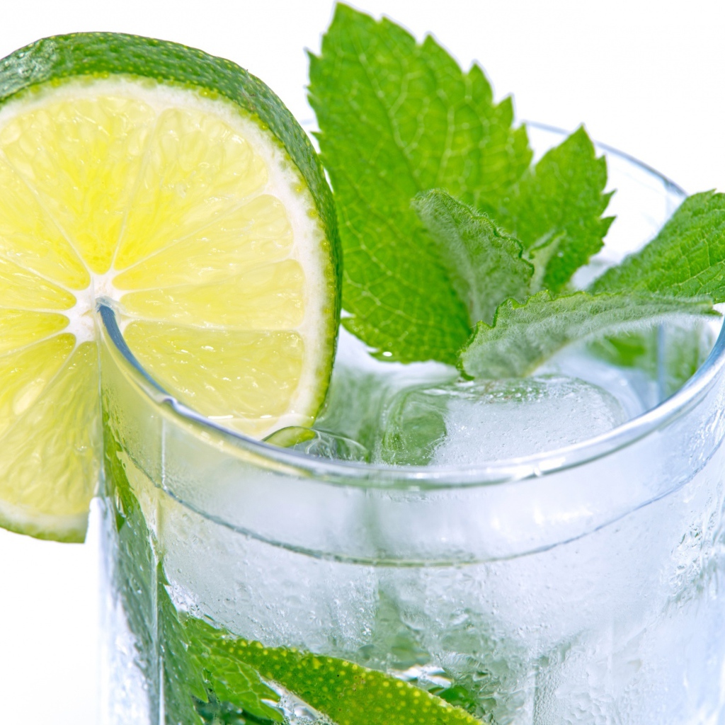 Стакан с освежающим напитком с мятой и лаймом на белом фоне