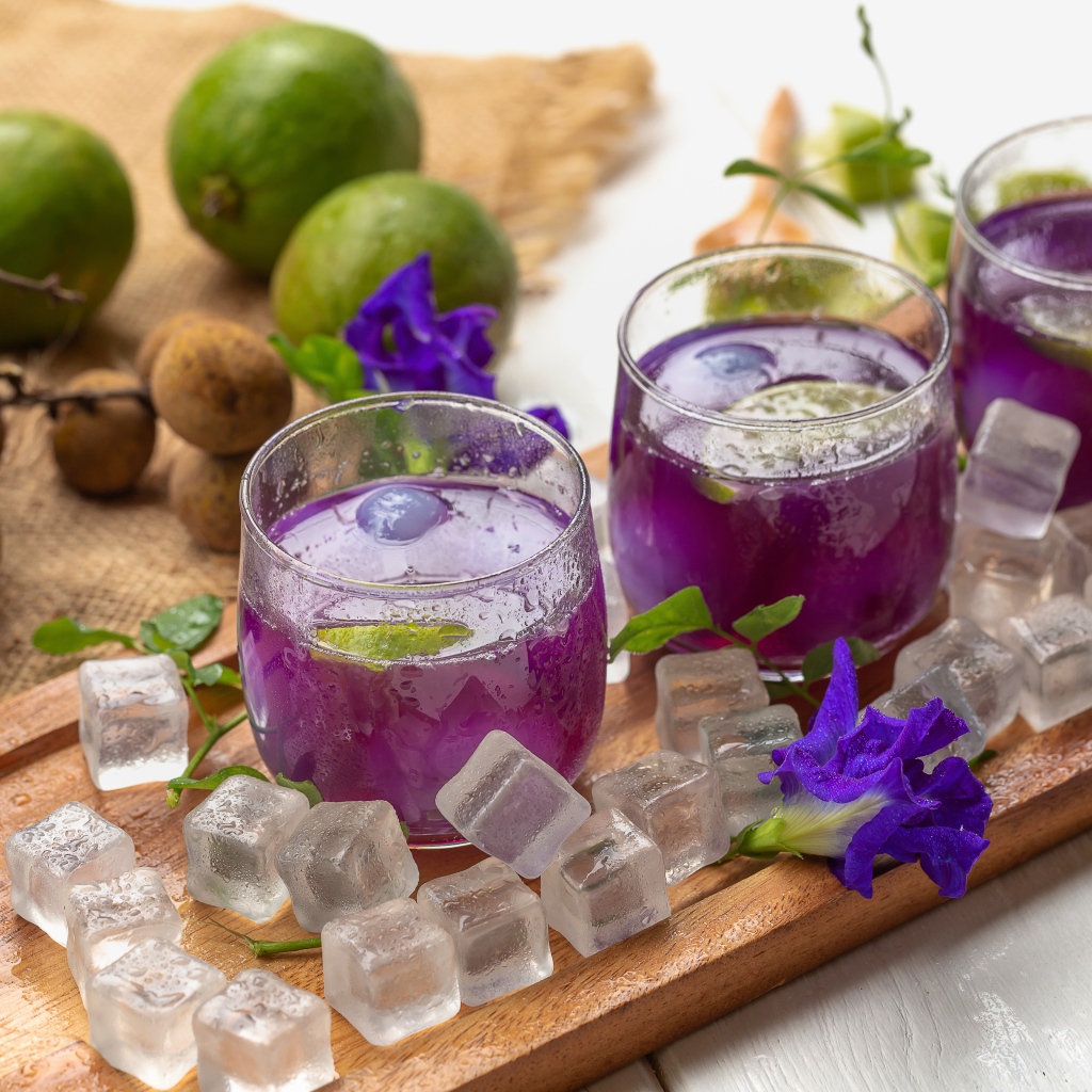 Стаканы с напитком на столе с лаймом и кубиками льда