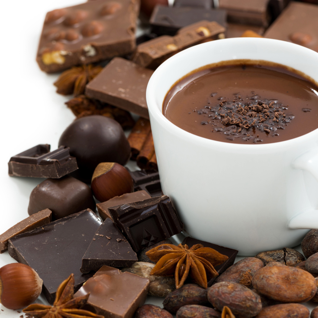 Горячий шоколад в белой чашке на столе с орехами