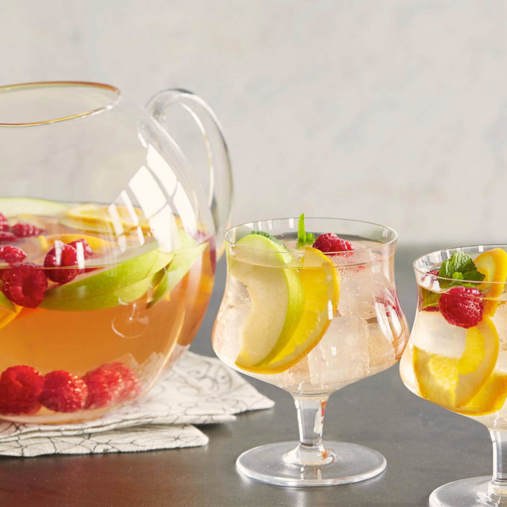 Лимонад в графине на столе с бокалами 