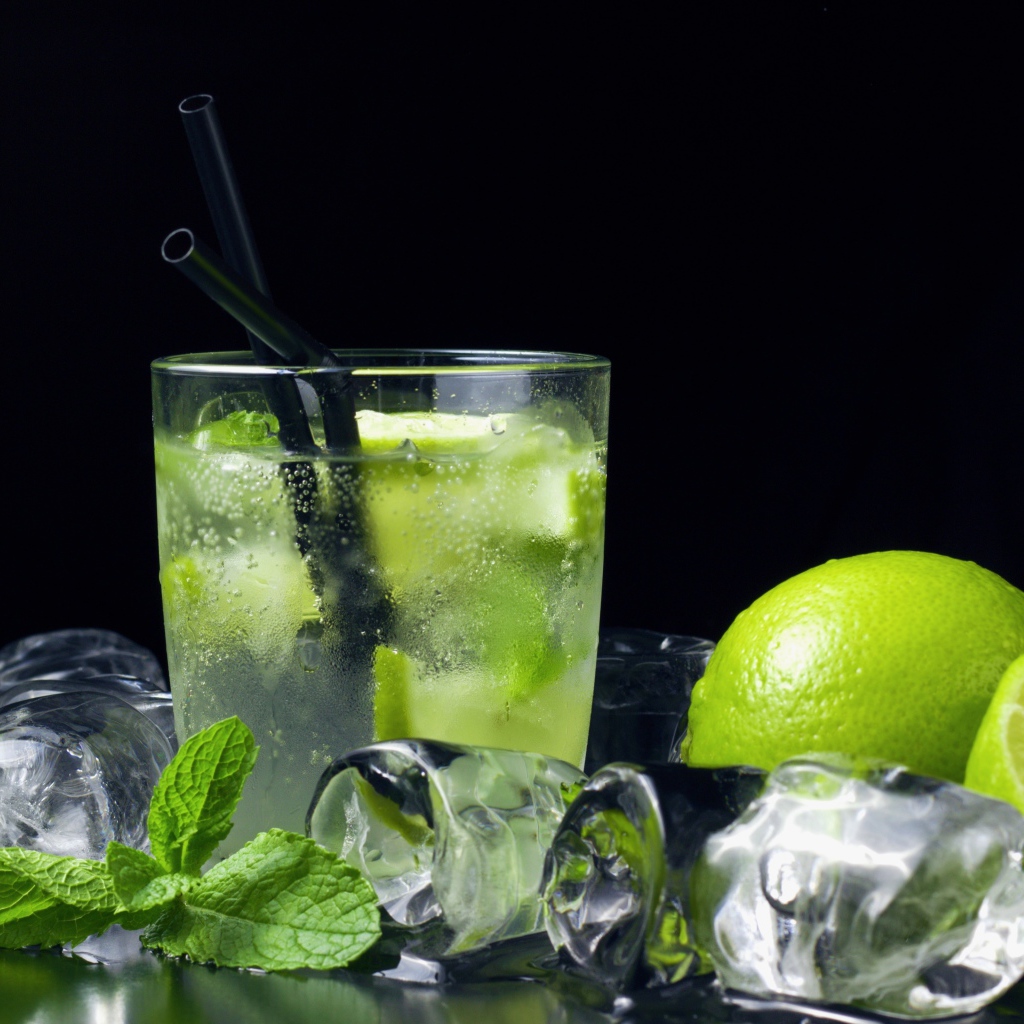 Коктейль мохито на черном фоне с лаймом и кубиками льда