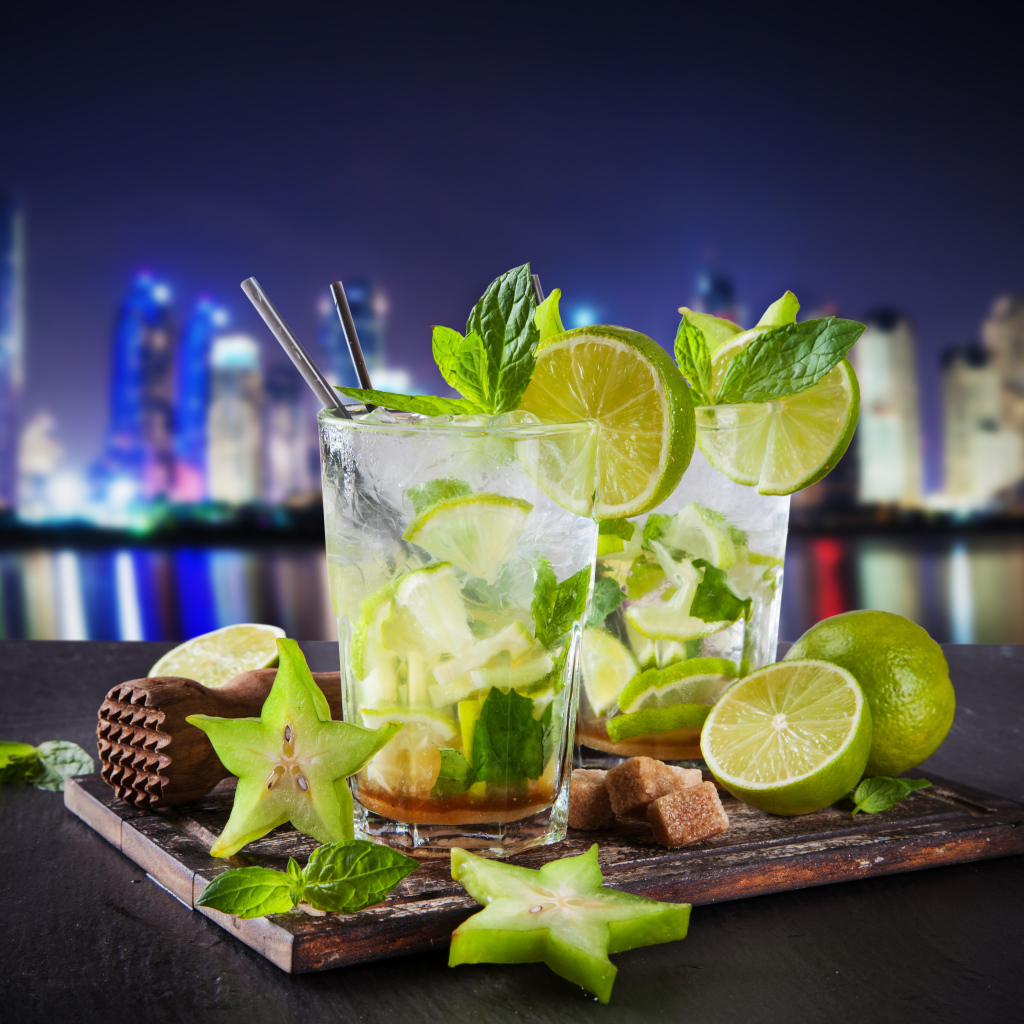 Коктейль мохито с лаймом и карамболью на фоне города