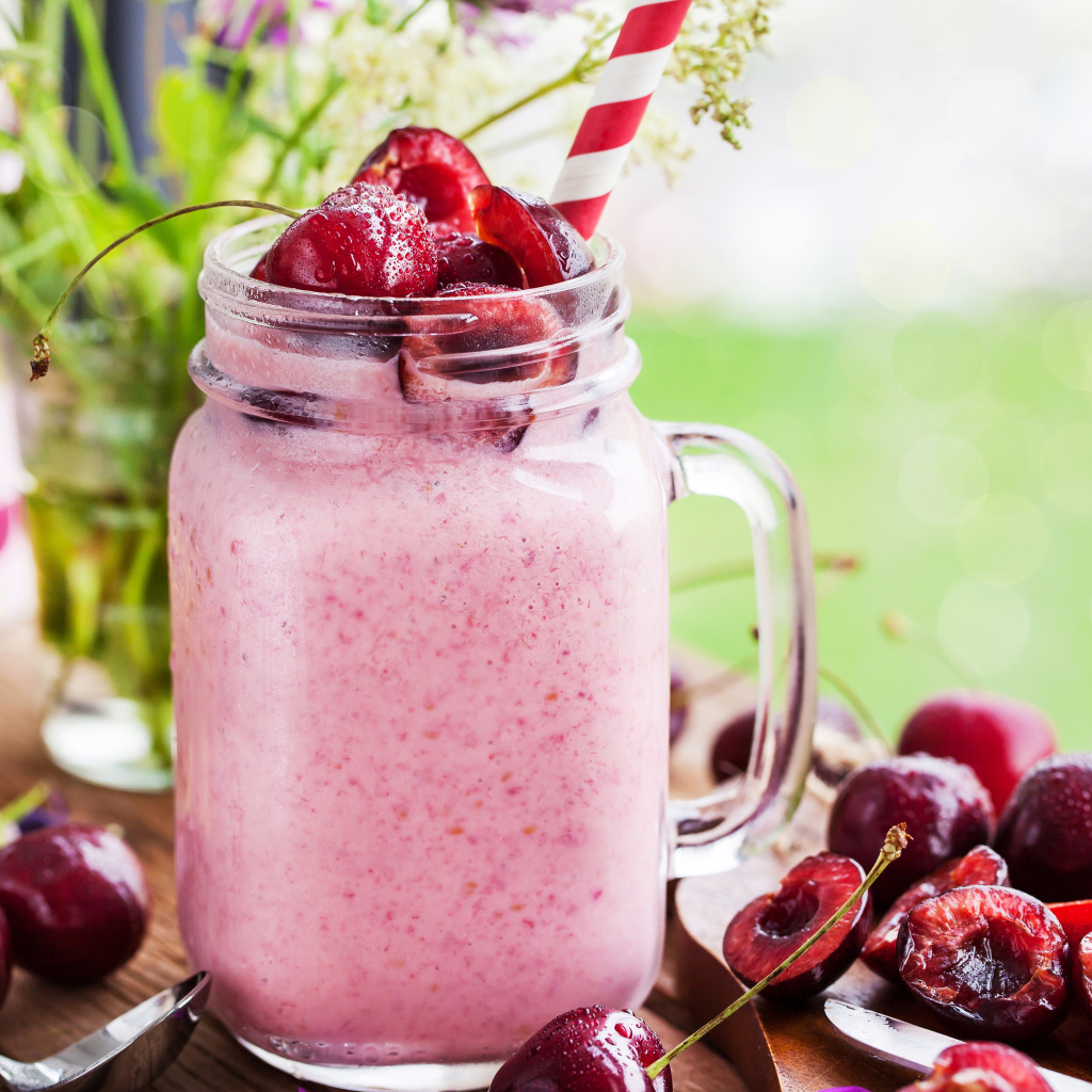Смузи в бутылке с трубочкой и ягодами черешни 
