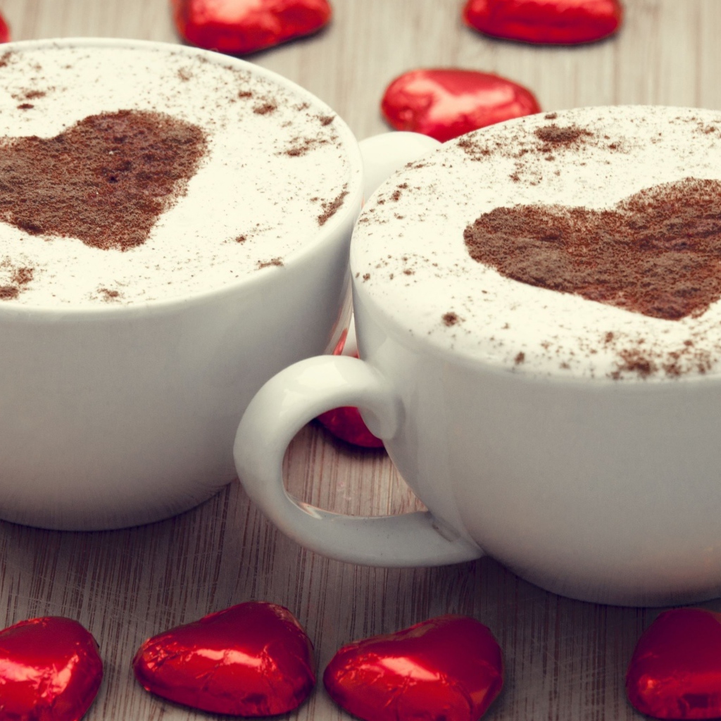 Две чашки кофе на столе с шоколадными конфетами в форме сердца
