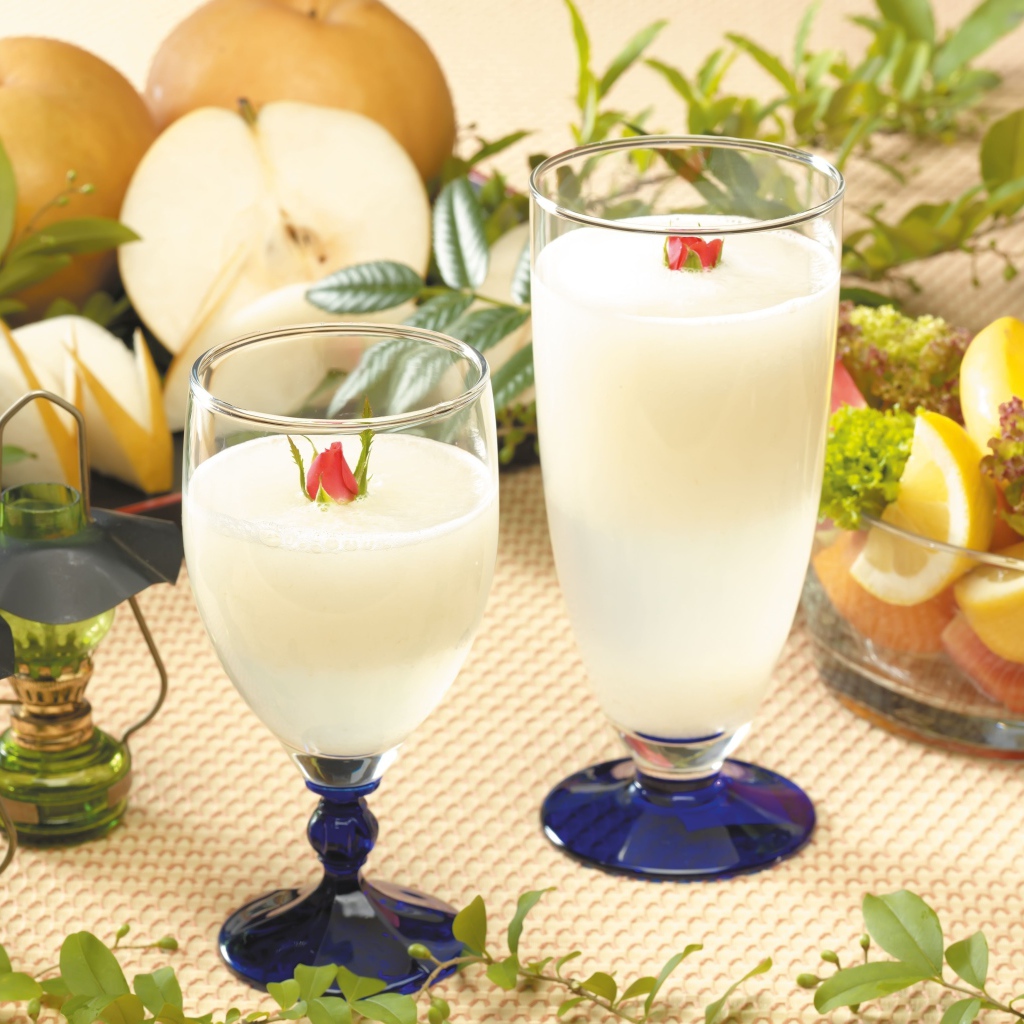 Два бокала сока на столе с фруктами