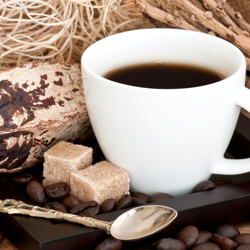 Белая чашка кофе с зернами и кусочками сахара на столе 