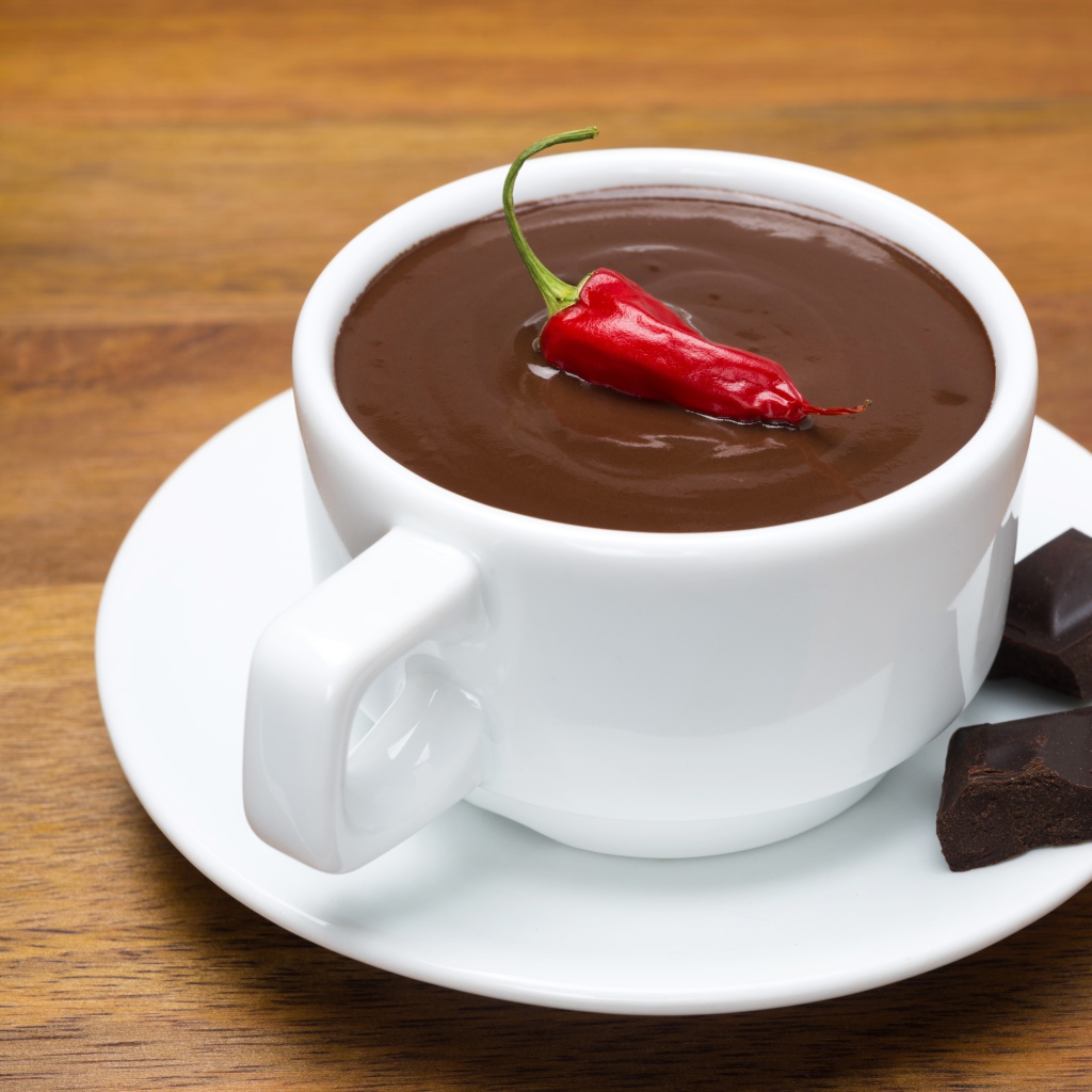 Белая чашка горячего шоколада с красным перцем