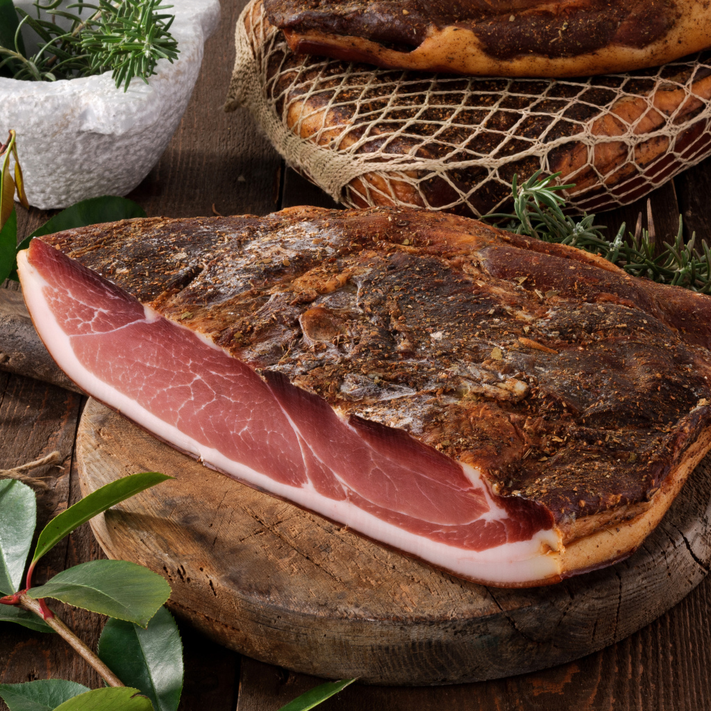 Кусок копченого мяса со специями на разделочной доске