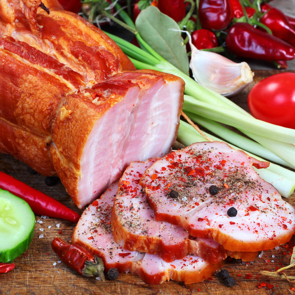Аппетитная ветчина со специями и свежими овощами на столе