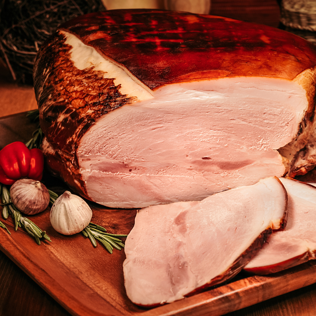 Аппетитный кусок ветчины с перцем и чесноком на доске