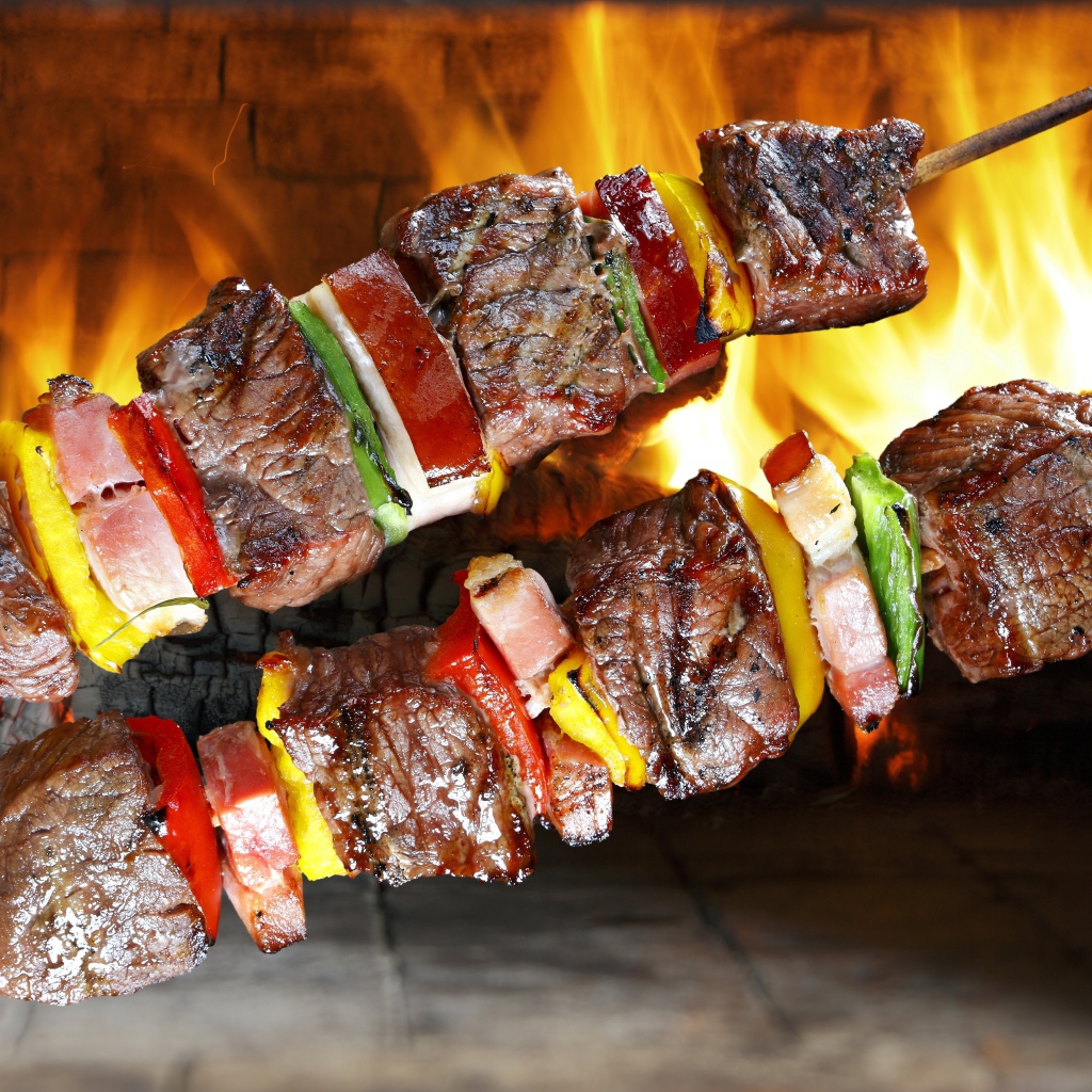 Аппетитный шашлык с овощами на фоне огня