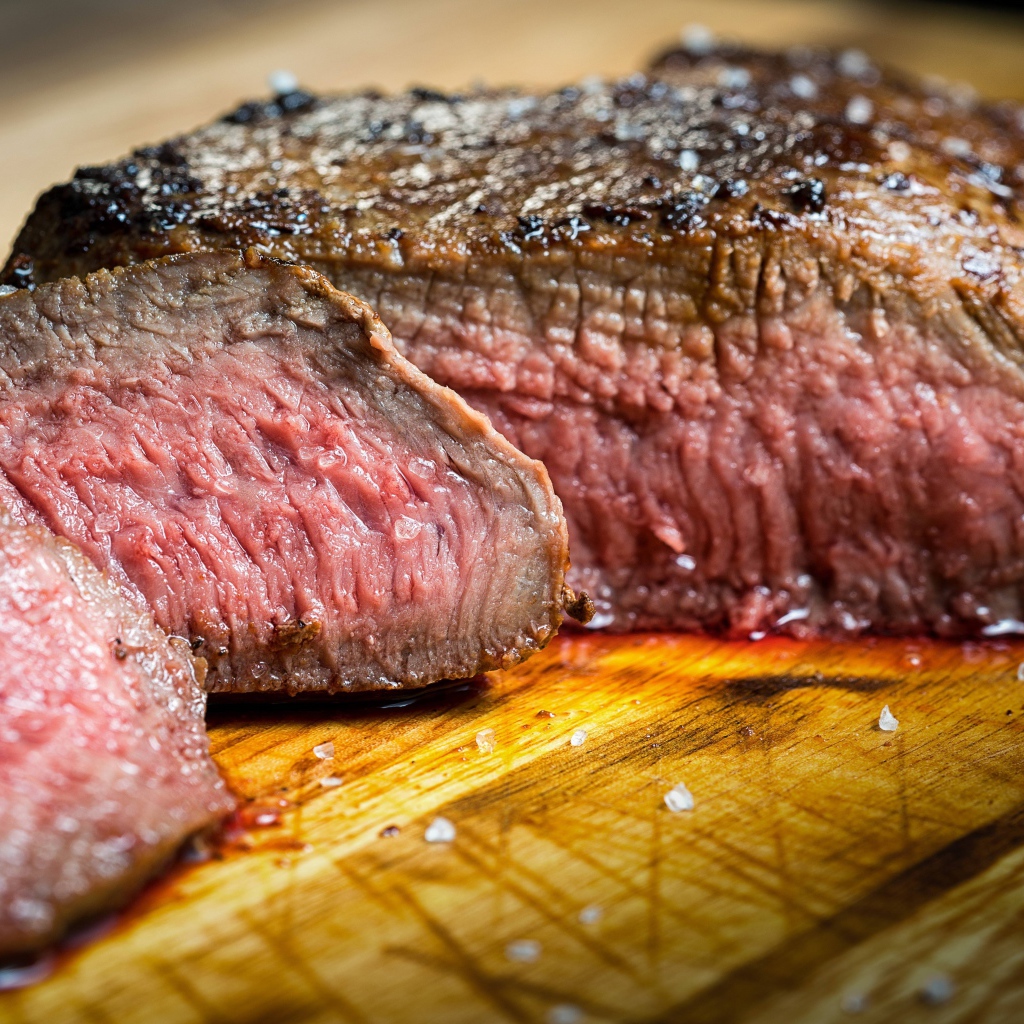 Аппетитный нарезанный кусок мяса на разделочной доске