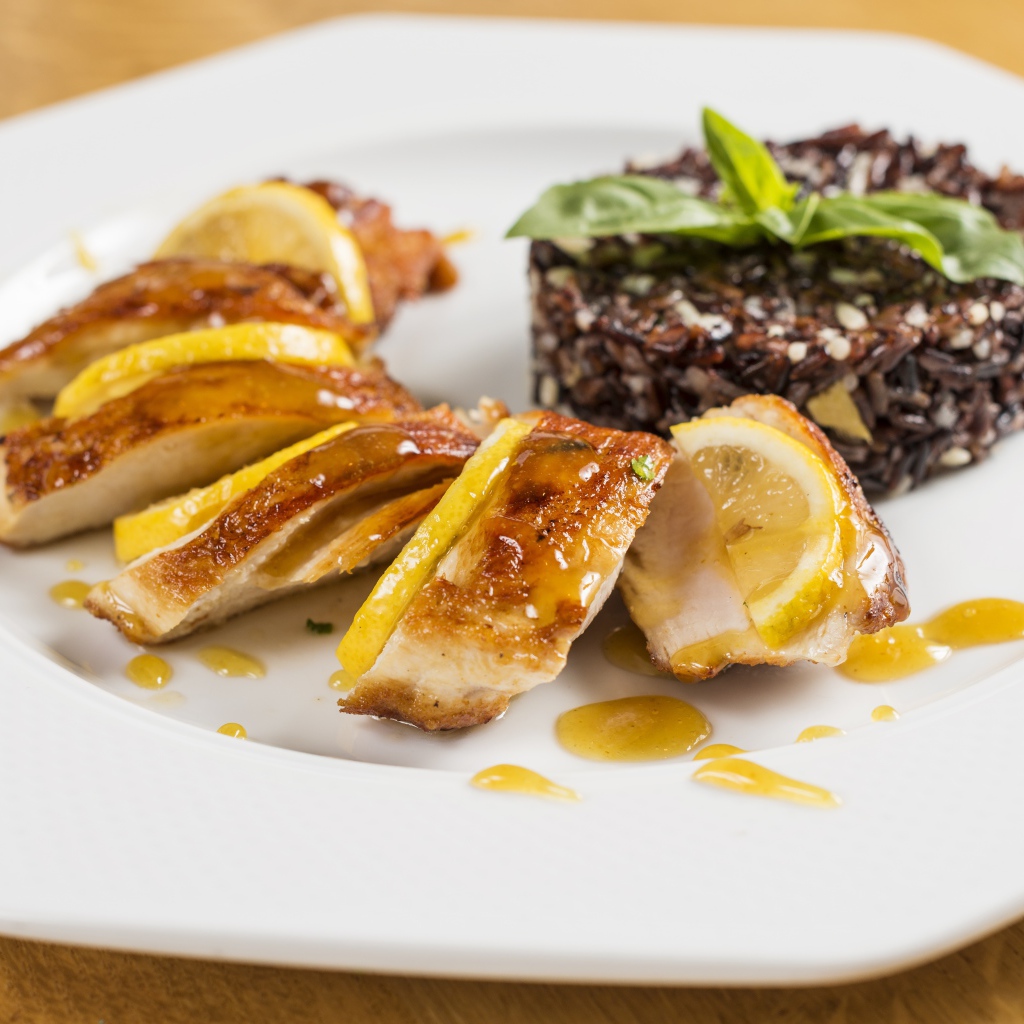 Куриный рулет на белой тарелке с рисом