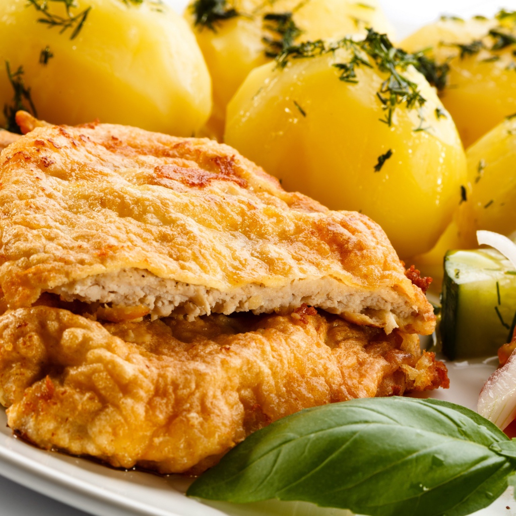 Отбивная на тарелке с вареным картофелем и салатом