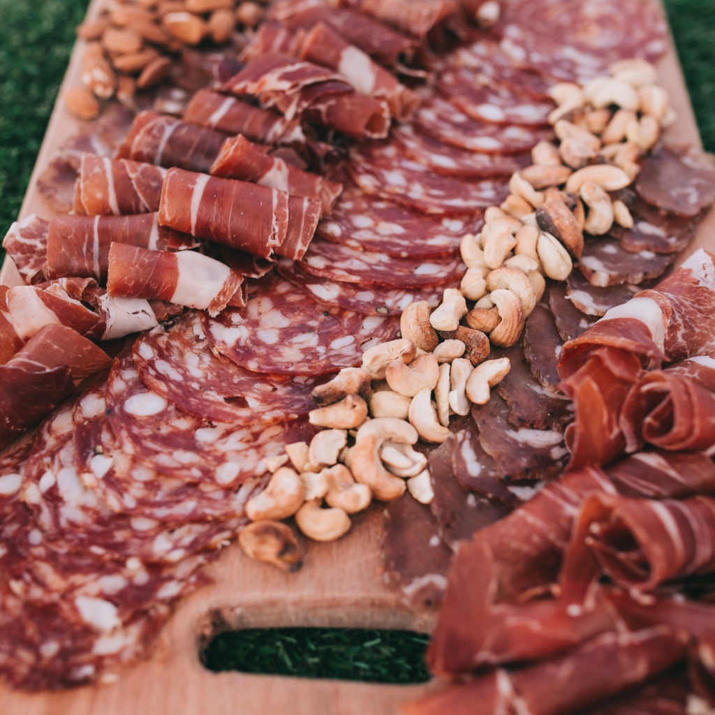 Мясная нарезка с орехами на разделочной доске