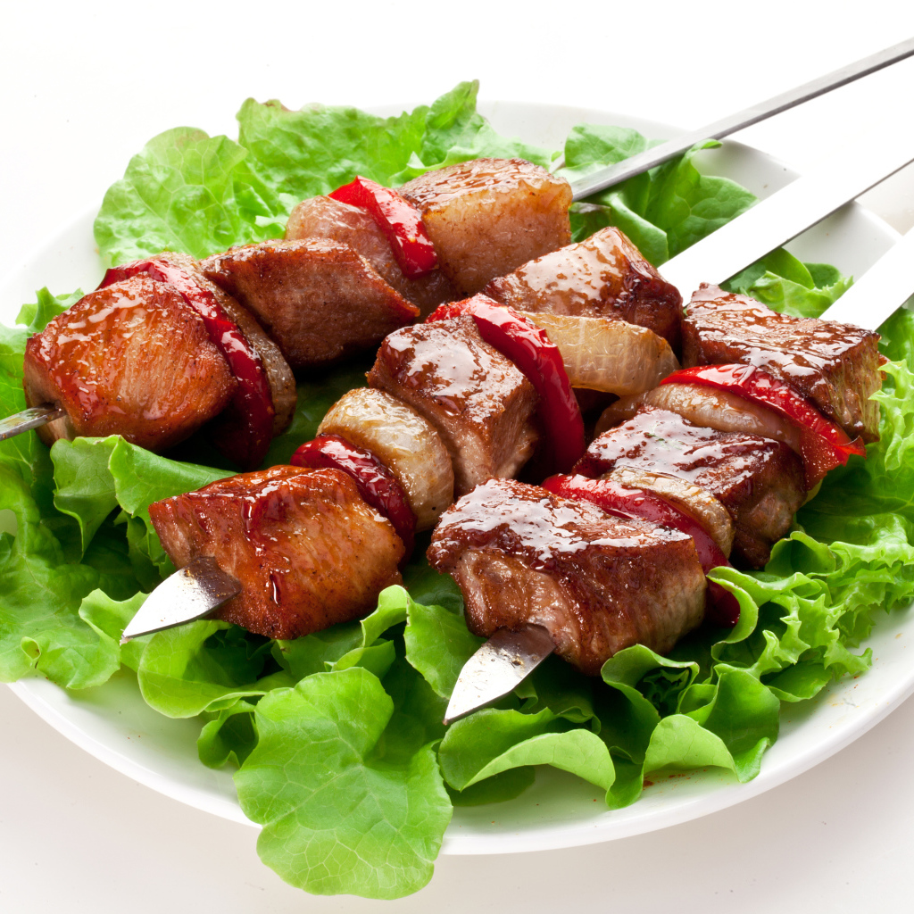 Аппетитный шашлык с листьями салата на шампурах 