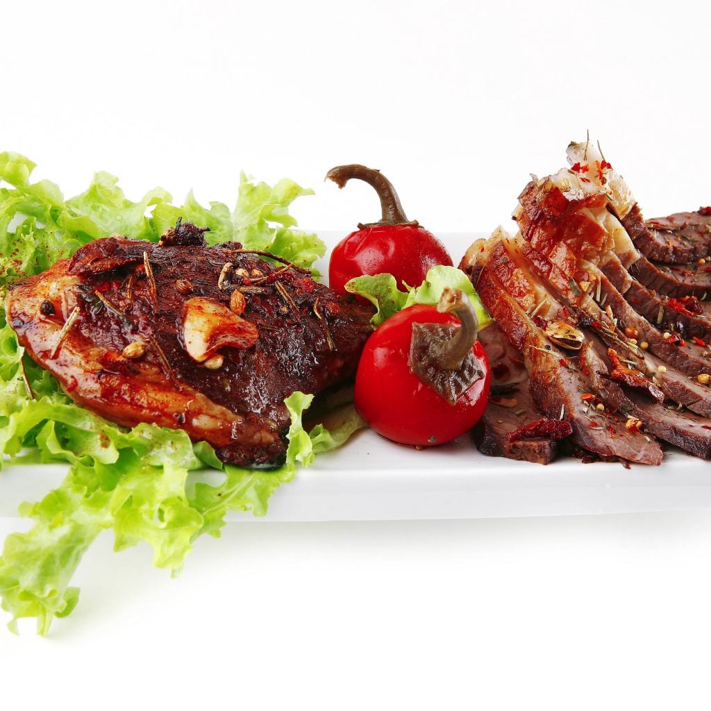 Мясо с листьями салата и красным перцем на белом фоне