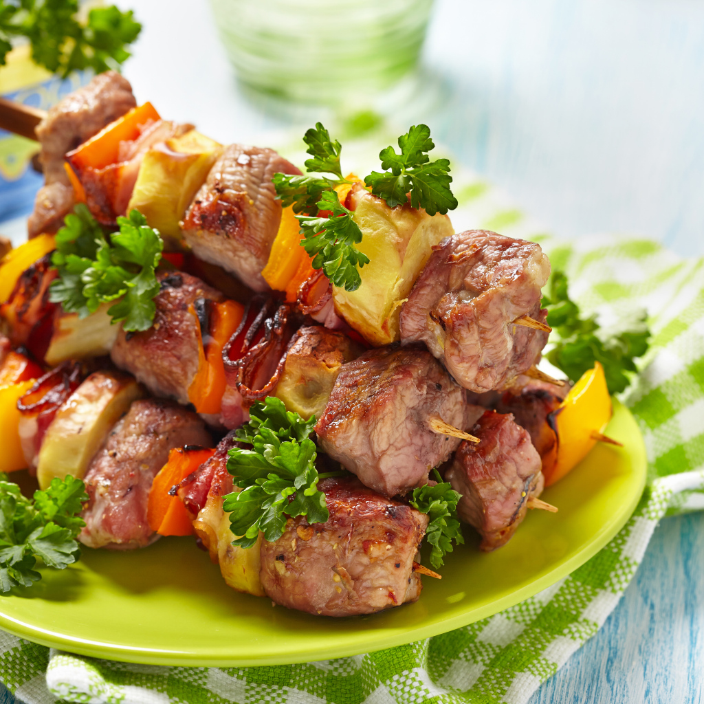 Шашлык с овощами на тарелке на столе