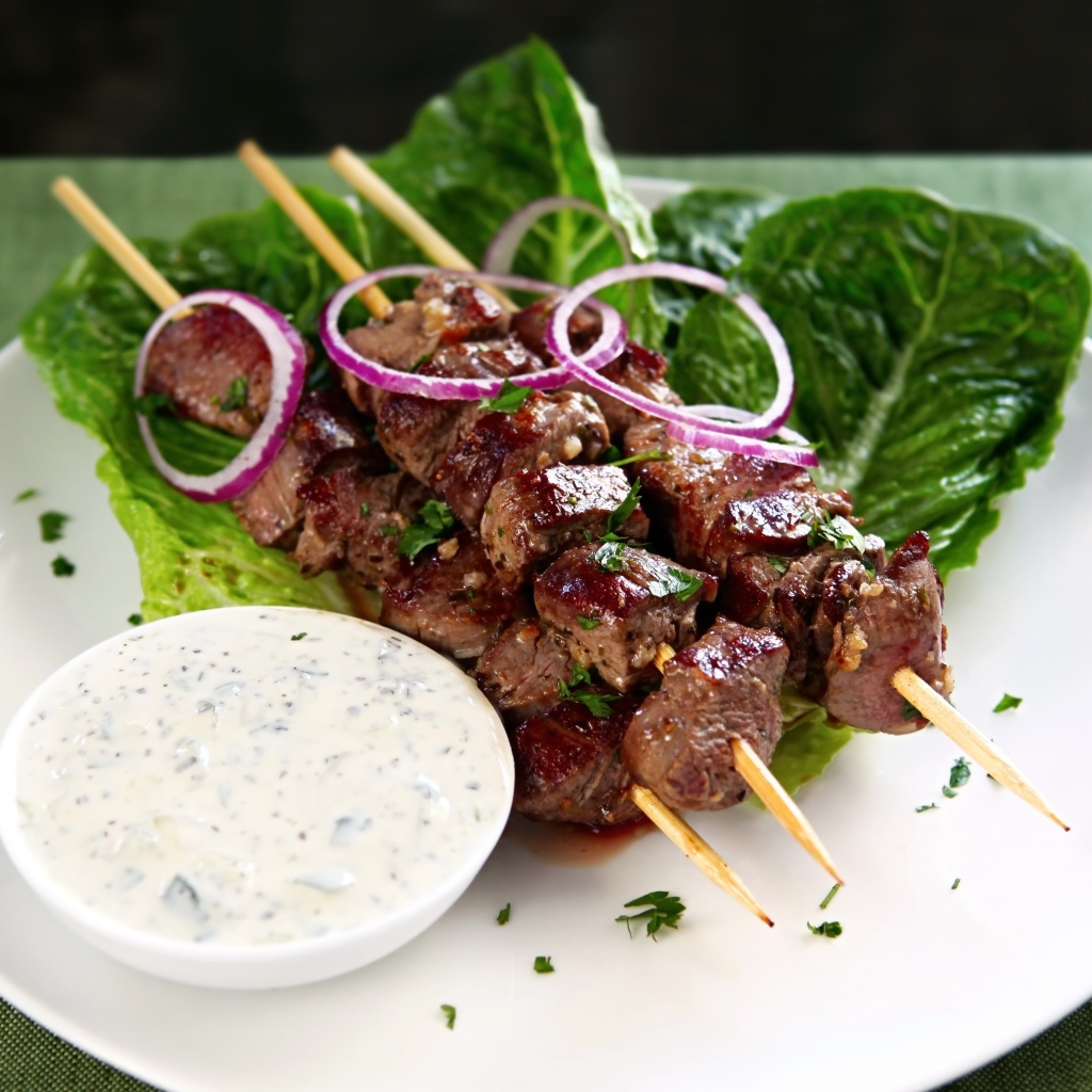 Вкусный шашлык на деревянных шампурах с соусом