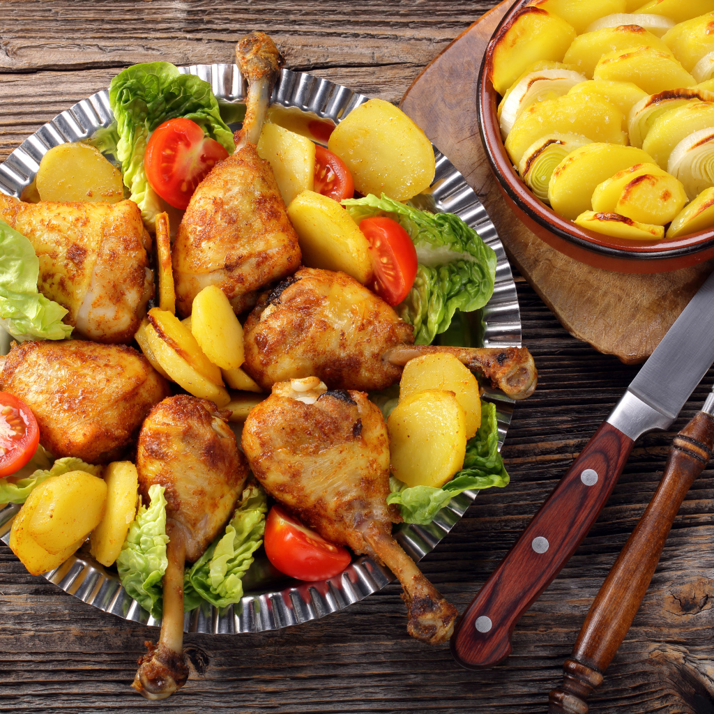 Запеченные куриные ножки с жареной картошкой на столе