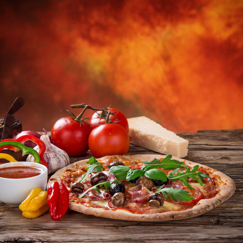 Пицца с колбасой и грибами на столе с соусом и овощами 