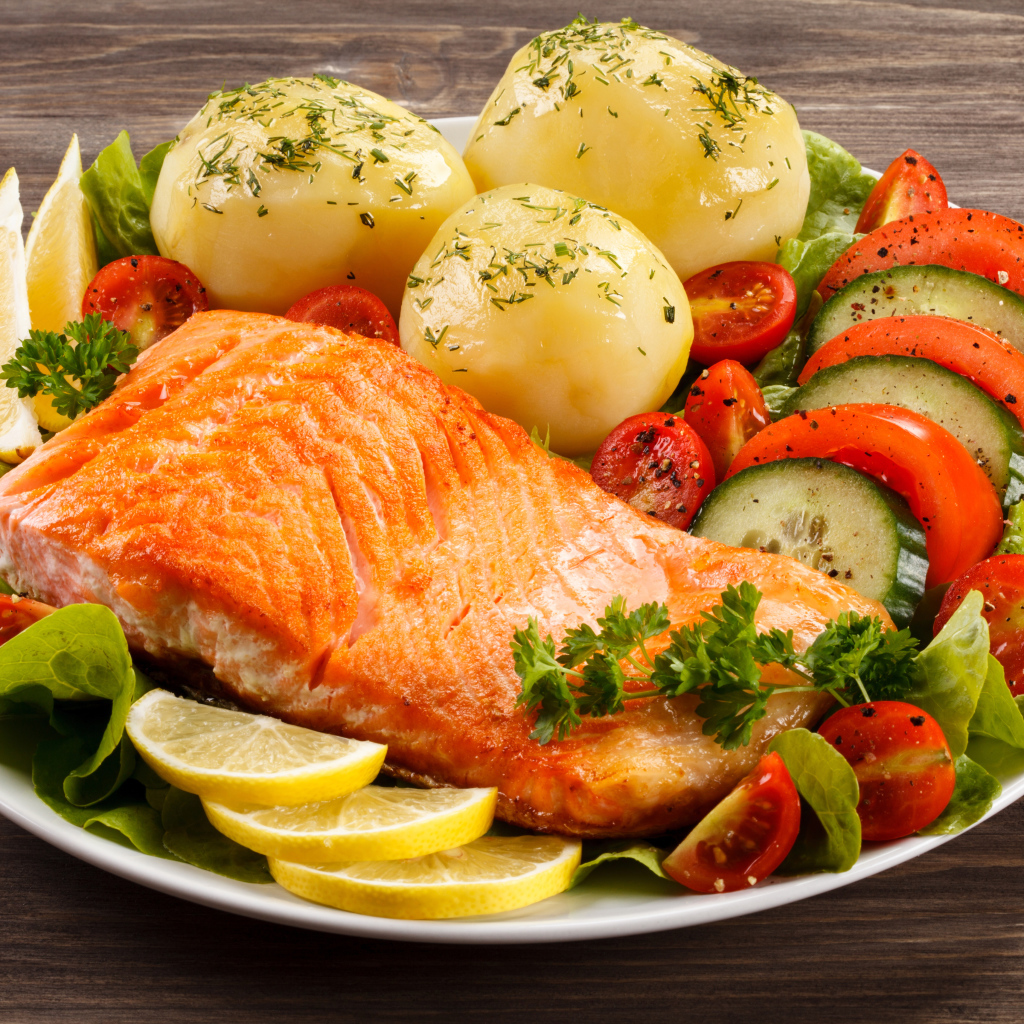 Кусок жареной рыбы на тарелке с овощами