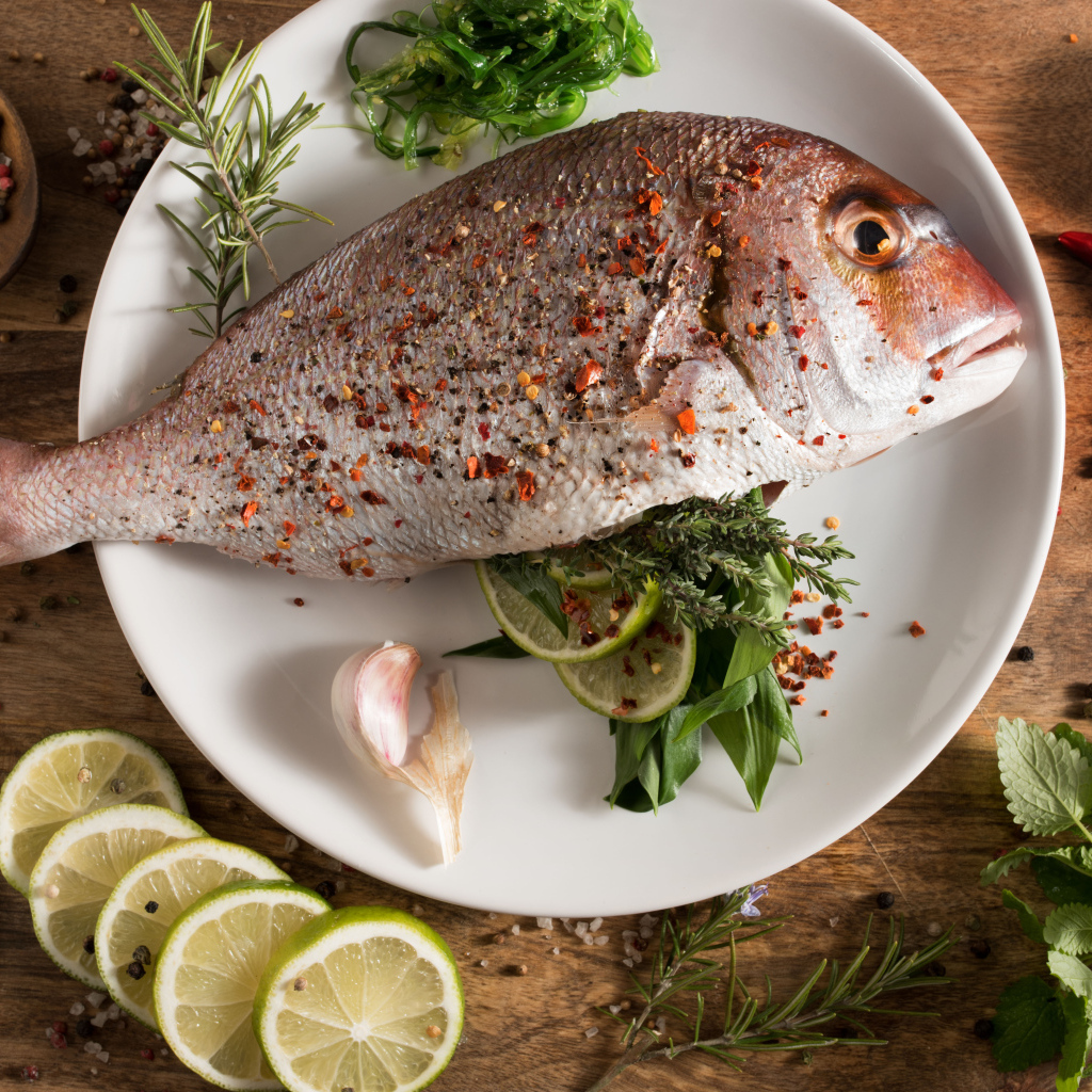 Рыба на тарелке со специями и лаймом