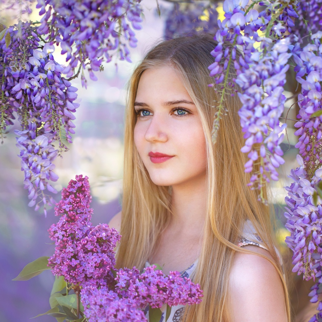 Красивая блондинка с букетом сирени на фоне цветов глицинии