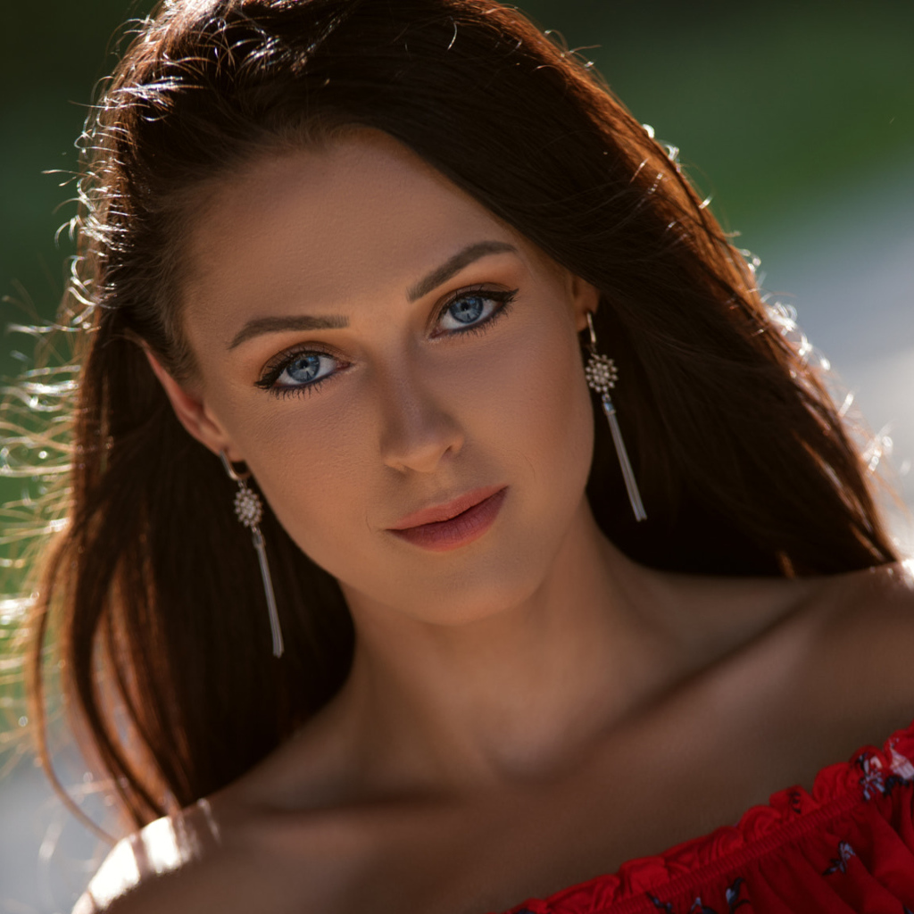 Красивая голубоглазая брюнетка с серьгами у ушах