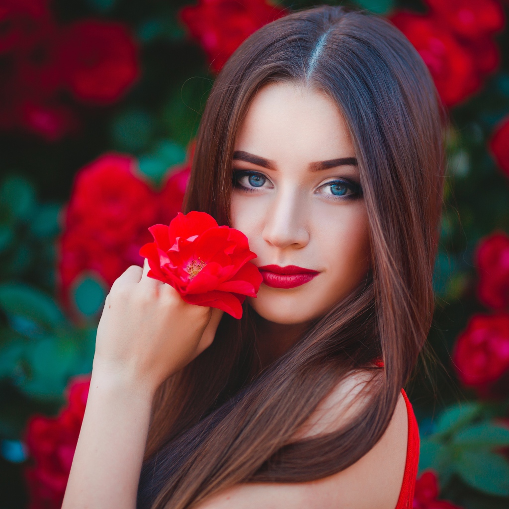 Красивая голубоглазая девушка с красной розой в руке