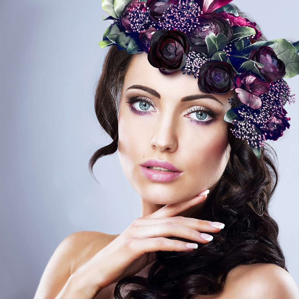Красивая голубоглазая девушка с венком на голове на сером фоне