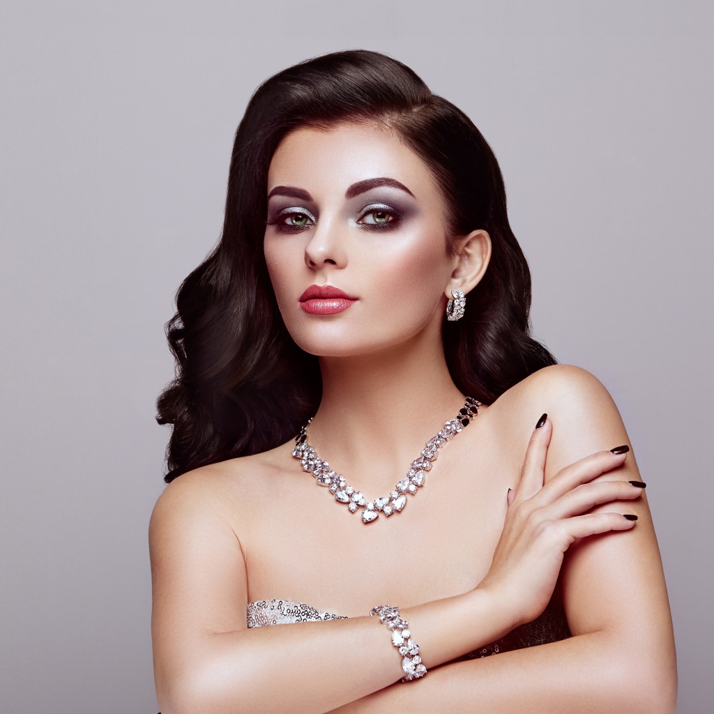 Красивая яркая брюнетка на сером фоне